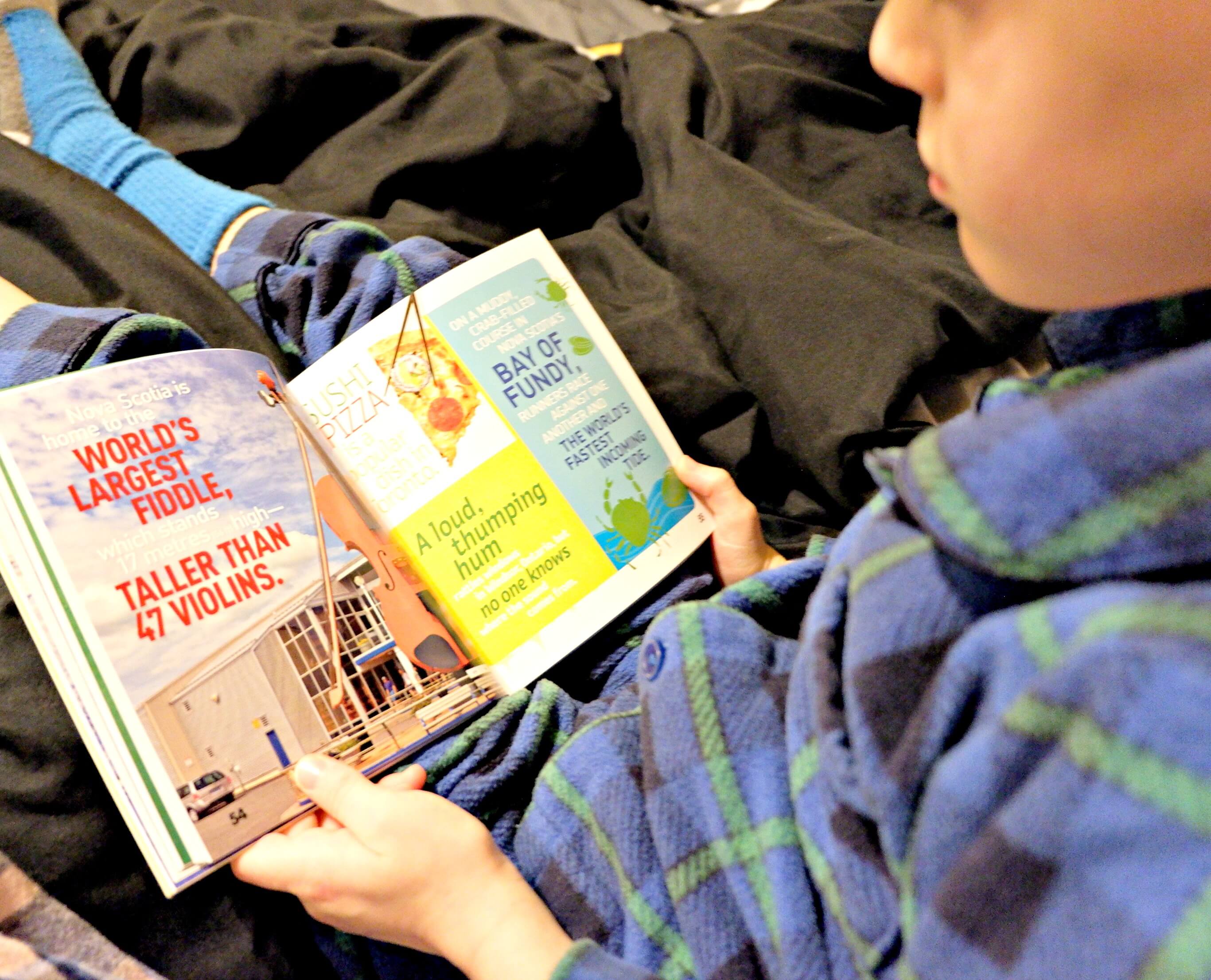 young boy reading in bed national geographic canada facts book weird but true bedtime reading pickle planet
